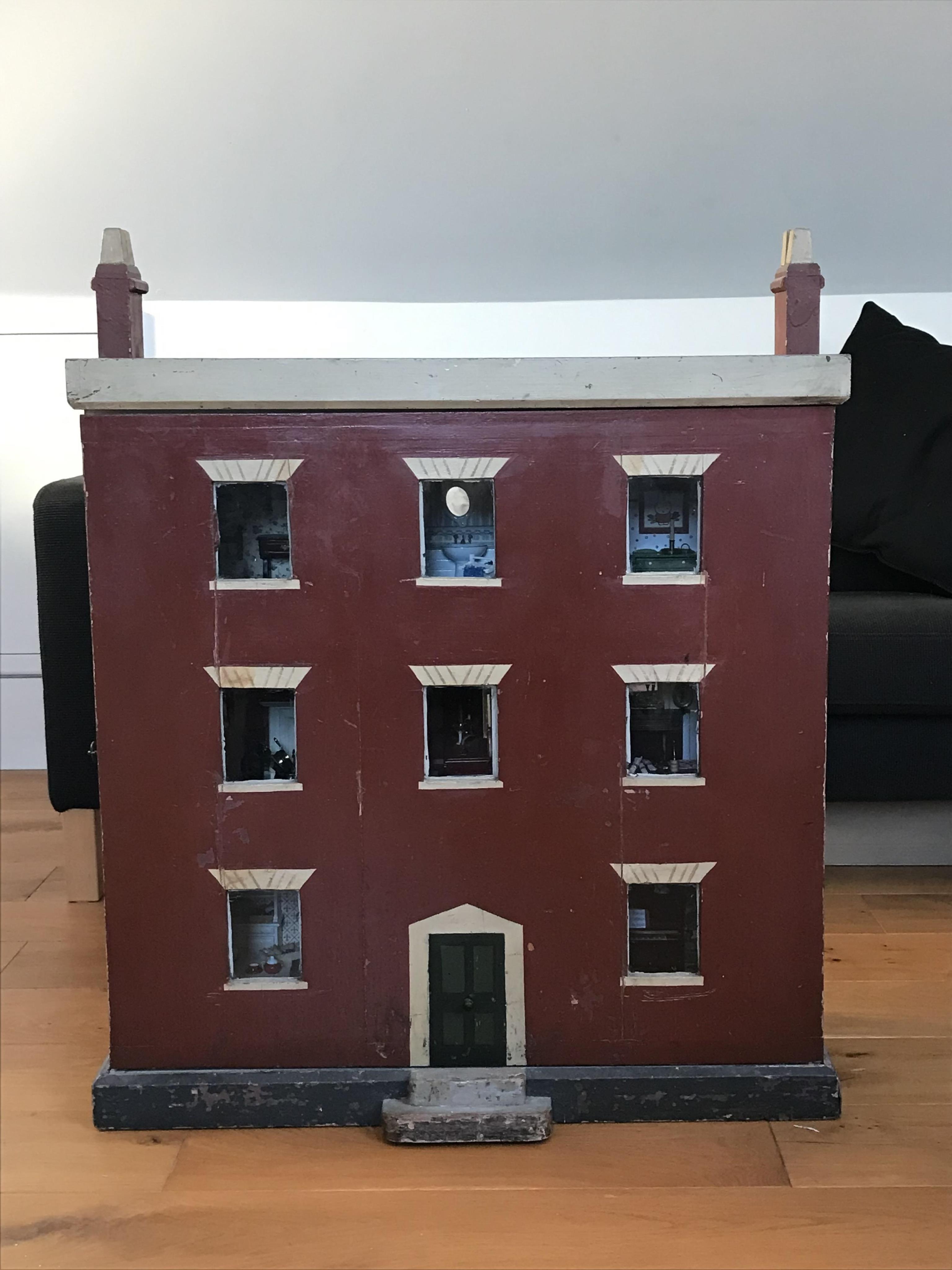 A late 19th century doll's house, with a single front opening panel, incorporating eight internal rooms, flat roof with parapet, dimensions 81.5cm high, 79cm wide, 30cm deep, together with modern manufactured furniture a